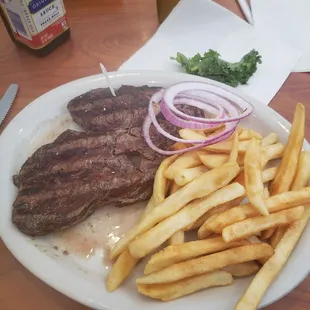 a plate of french fries and steak
