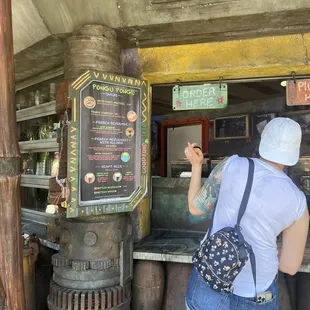 a woman standing in front of a food stand