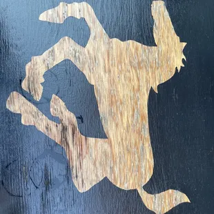 the silhouette of a horse on a wooden sign