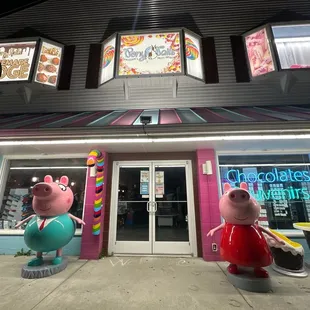 the outside of a store with a giant pig and a little pig