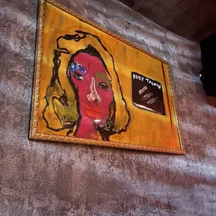 a painting of a woman's face on a wall