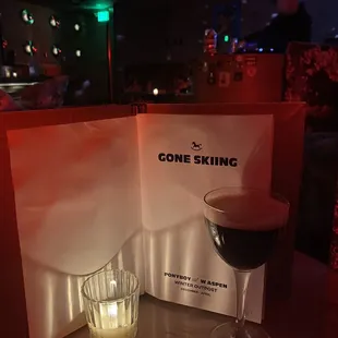 a glass of wine next to a menu