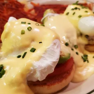 a plate of eggs benedicts and hash browns