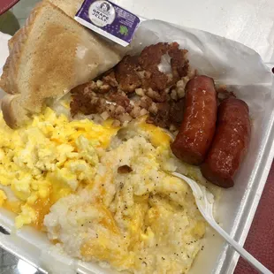 Corned beef hash breakfast with cheese grits, eggs, toast and a side of smoked sausage.