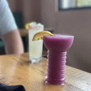 a purple drink with a lemon wedge
