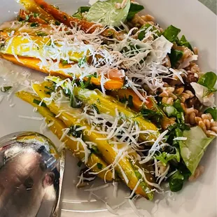 a white plate with a salad and a spoon