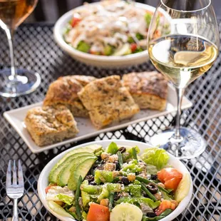 a plate of salad and a glass of wine