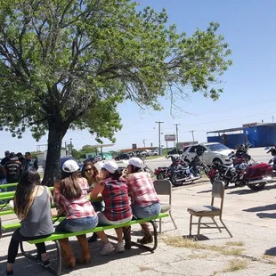 a group of people sitting at picnic tables