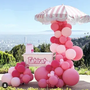  a stand with balloons and an umbrella