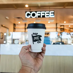 a hand holding a cup of coffee