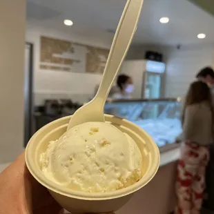 a hand holding a cup of ice cream