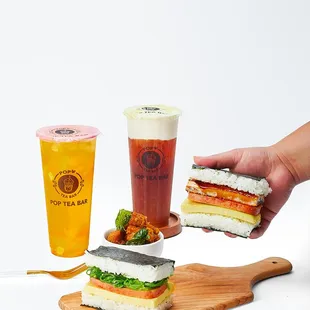 a person holding a sandwich and a drink