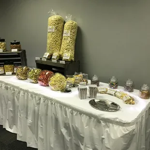 a buffet table with popcorn, candy, and other snacks