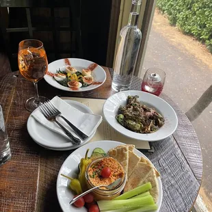 Deviled eggs, Brussels, hummus plate, and a aperol spritz.