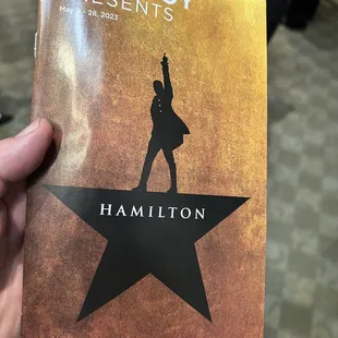 a hand holding a concert program