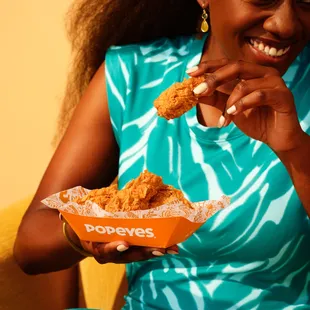 a woman eating a fried chicken sandwich