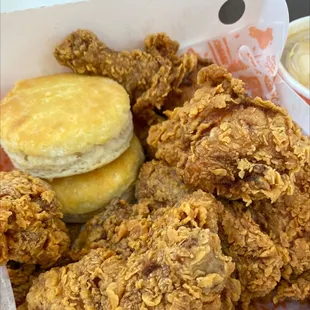 a basket of fried chicken and a biscuit