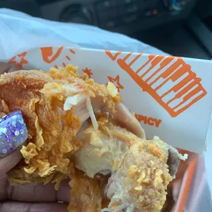 a hand holding a fried chicken sandwich