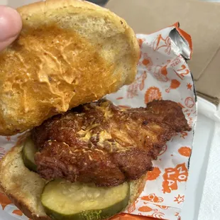 a hand holding a sandwich