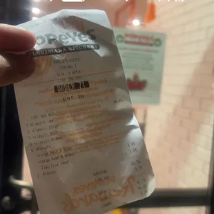 a hand holding a receipt