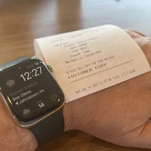 a person holding a receipt on their wrist