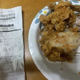 a plate of fried chicken and a receipt