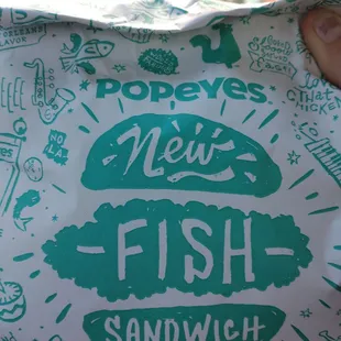 a hand holding a sandwich wrapper