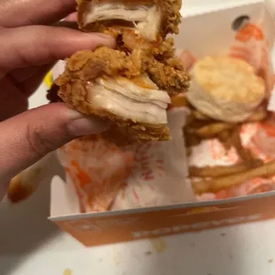 a hand holding a fried chicken sandwich