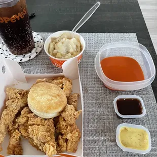 a tray of fried chicken, macaroni and cheese, and a drink