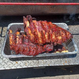a tray of ribs on a grill