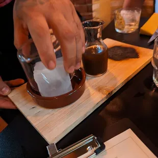 a person pouring something into a glass