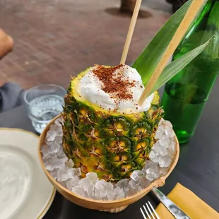 a pineapple with whipped cream on top