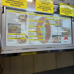 a man standing in front of a menu board