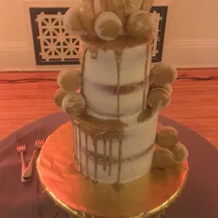 There's gold drizzle and gold brushed vanilla French macarons on this gilded wedding cake! What a masterpiece!