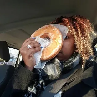 a woman in a car eating a donut