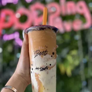 a hand holding a cup of boba tea