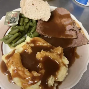a plate of mashed potatoes, gravy and green beans
