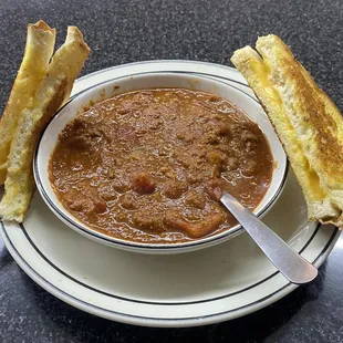 a bowl of chili and a grilled cheese sandwich