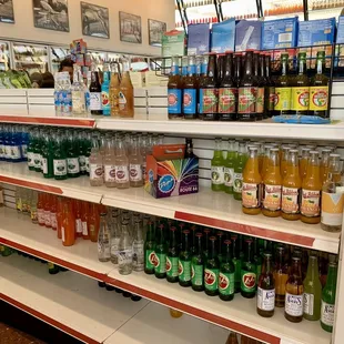 Room temperature soda bottles on the shelves.