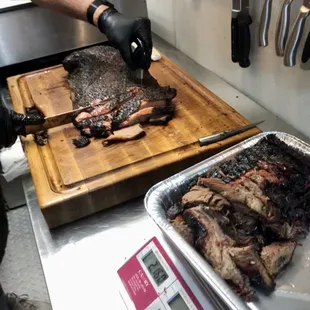 a man cutting meat on a cutting board