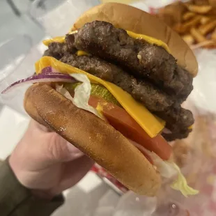 a hand holding a hamburger