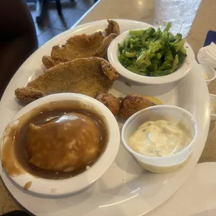 Catfish meal with mashed potatoes and broccoli.