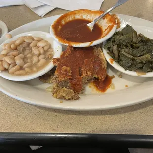 Meatloaf with gravy on the side, northern beans, turnip greens and corn bread muffin.