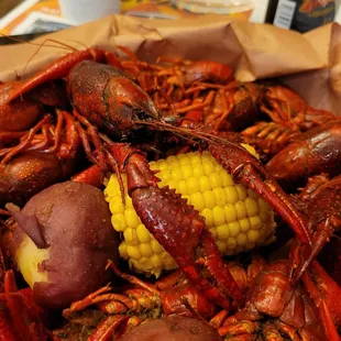 a pile of crawfish, corn and potatoes