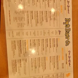 a menu and a drink on a table