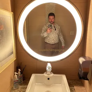 a man taking a selfie in a bathroom mirror