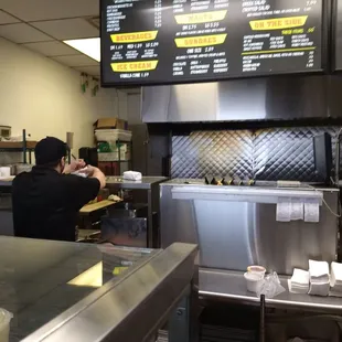 Look at the top of the counter strewn with onions and leftover fries.