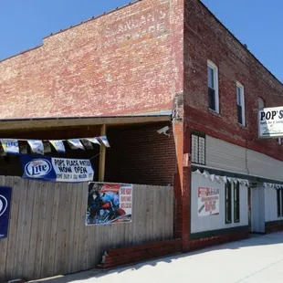 a brick building with a sign that says pop&apos;s place