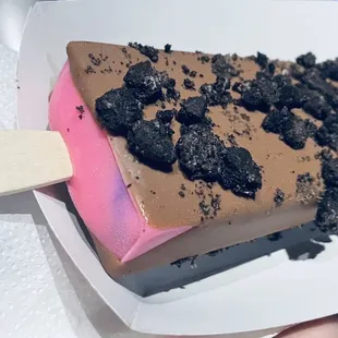 Bubble gum dipped in milk chocolate with Oreo crumbles