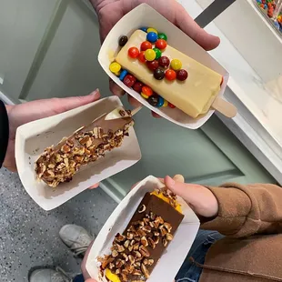 a person holding a box of candy and a piece of cake